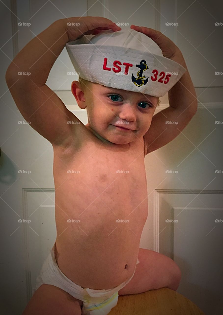 Shirtless cute baby boy wearing hat