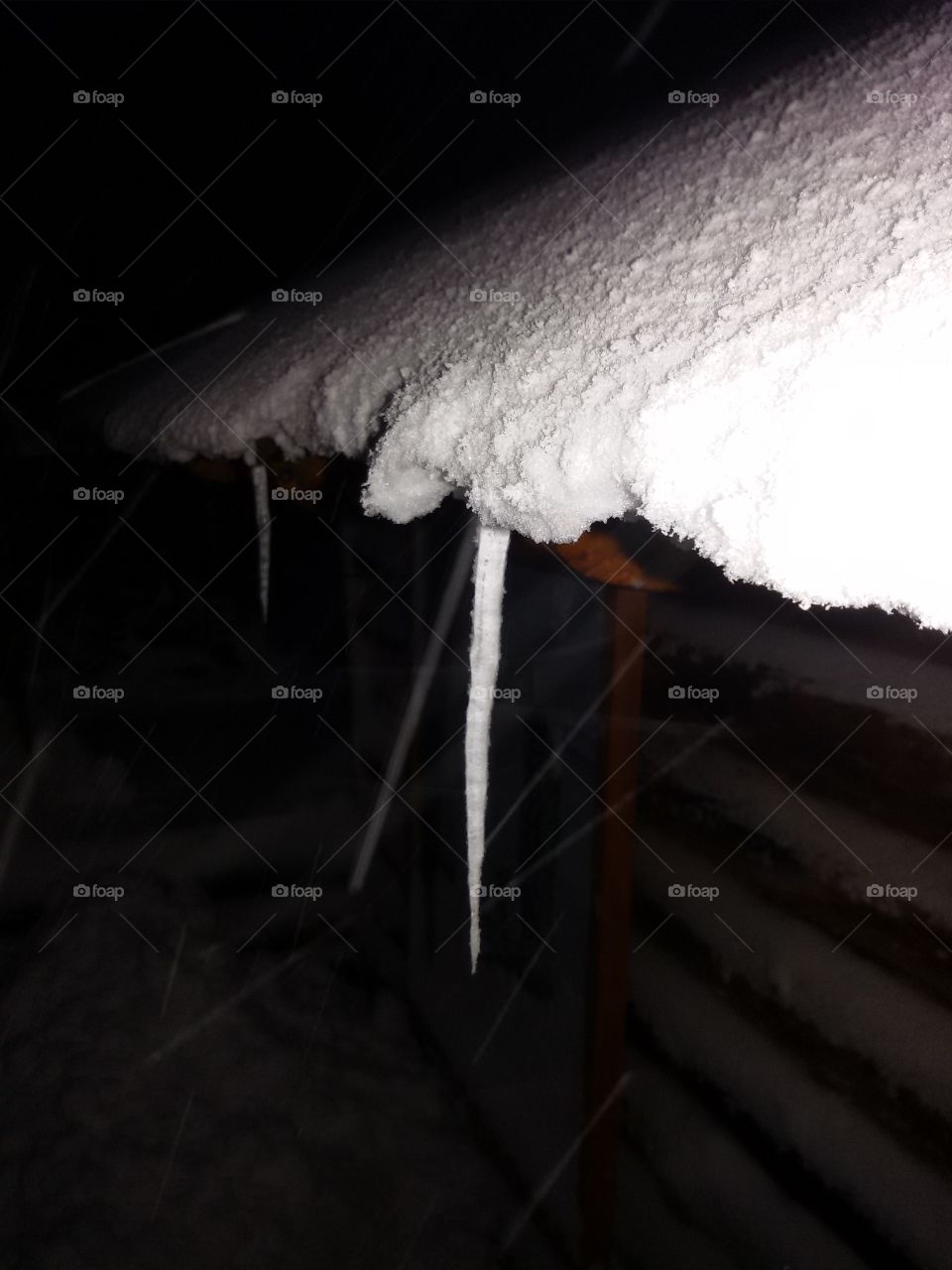 Icicle on a snowy roof