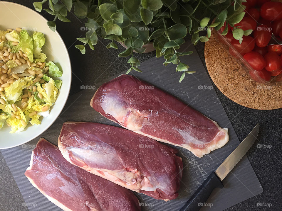 Raw duck fillet at the black table. Food flatlay