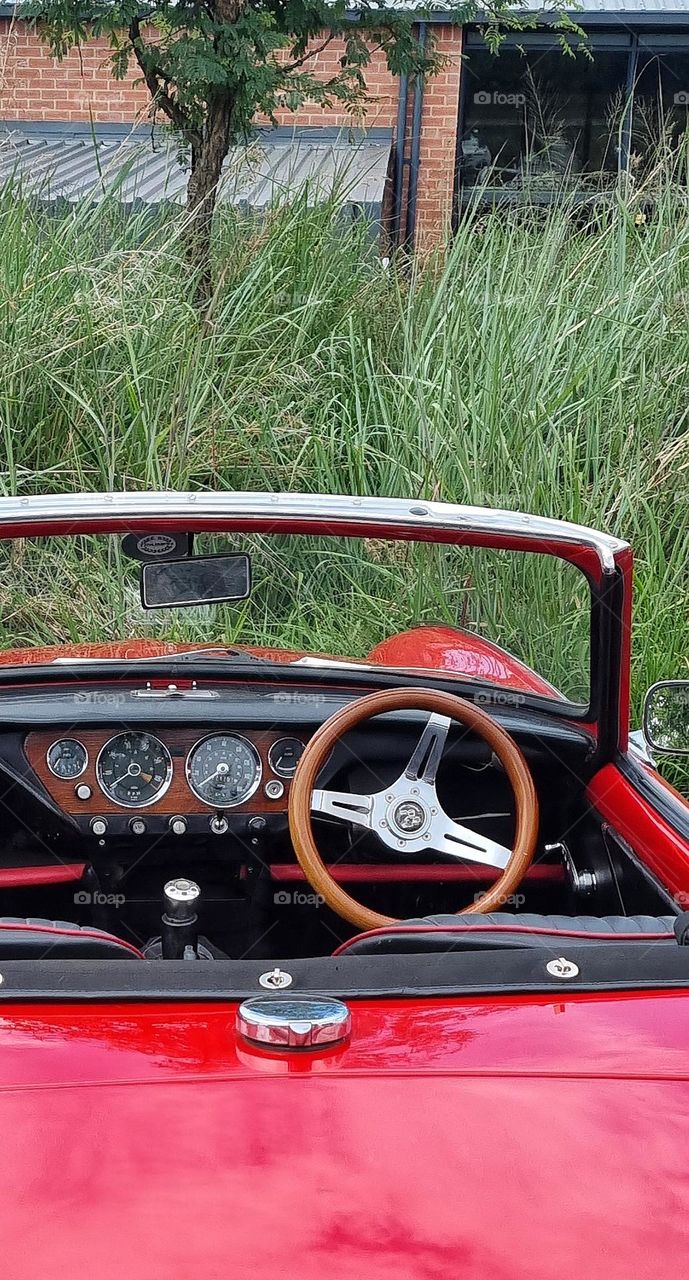 classic car with circular steering wheel and indicators on the dash.