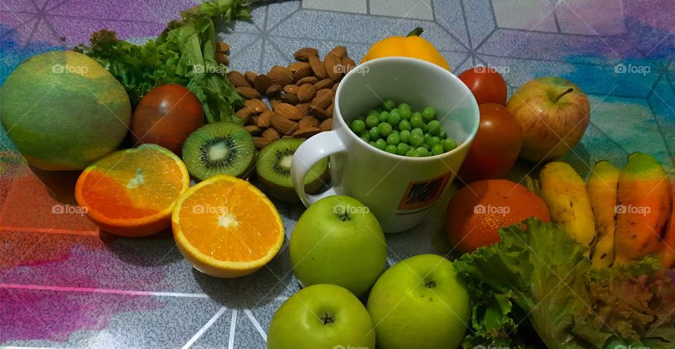 Healthy fruits apples Tomato’s orange  nut roasted lettuce leaf kiwi peas white background 