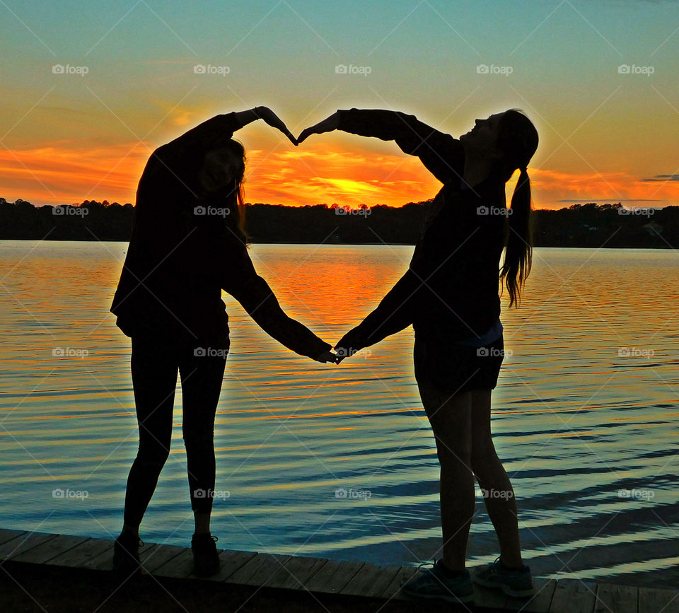 Memories of summer - Friends encompass the glorious sunset in their heart shaped figure