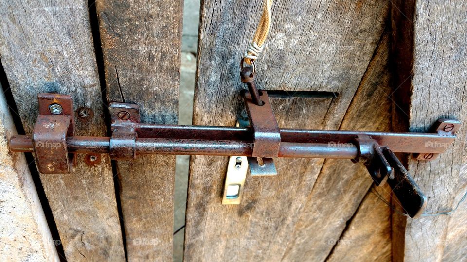 Velha fechadura de ferro em portão de madeira.