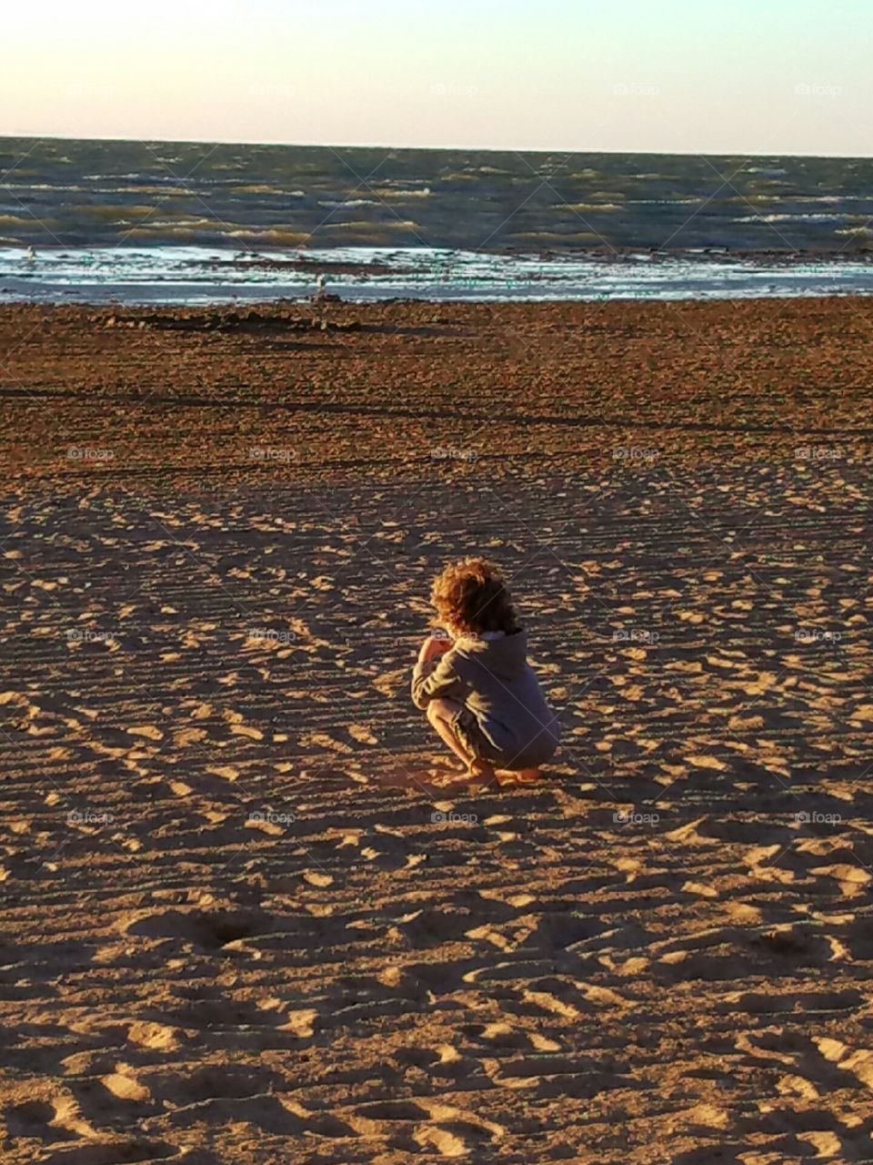 boy sitting on the beach