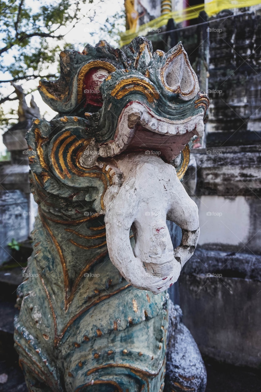Statue of dog eating a woman at a temple in Chiang Mai, Thailand 