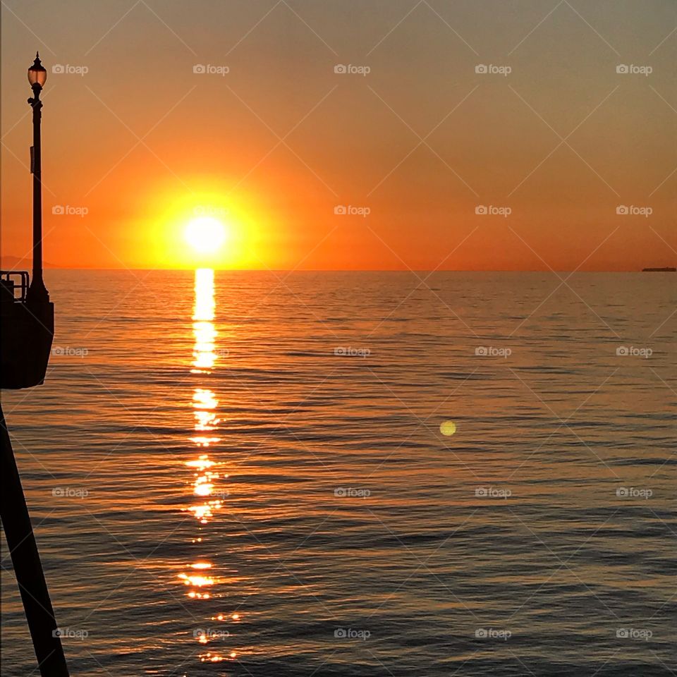 Orange sun setting on the horizon over the ocean