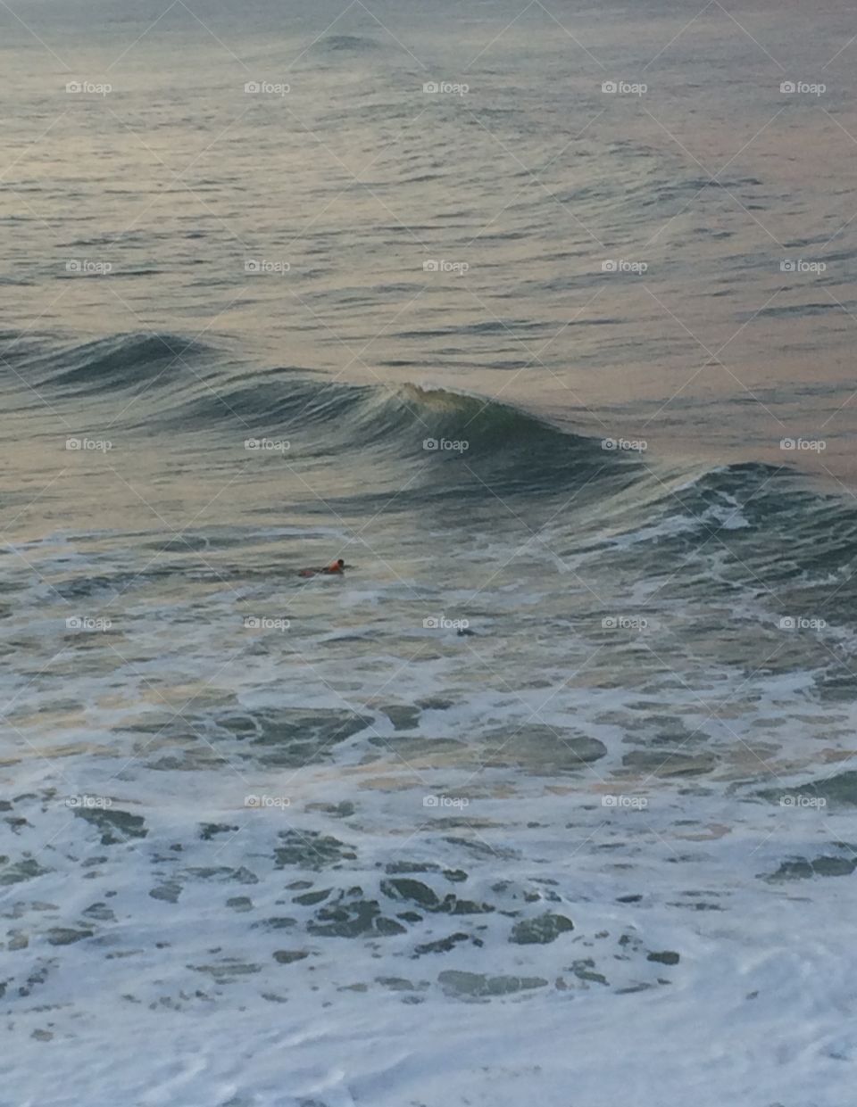 lone surfer. lone surfer paddling out back