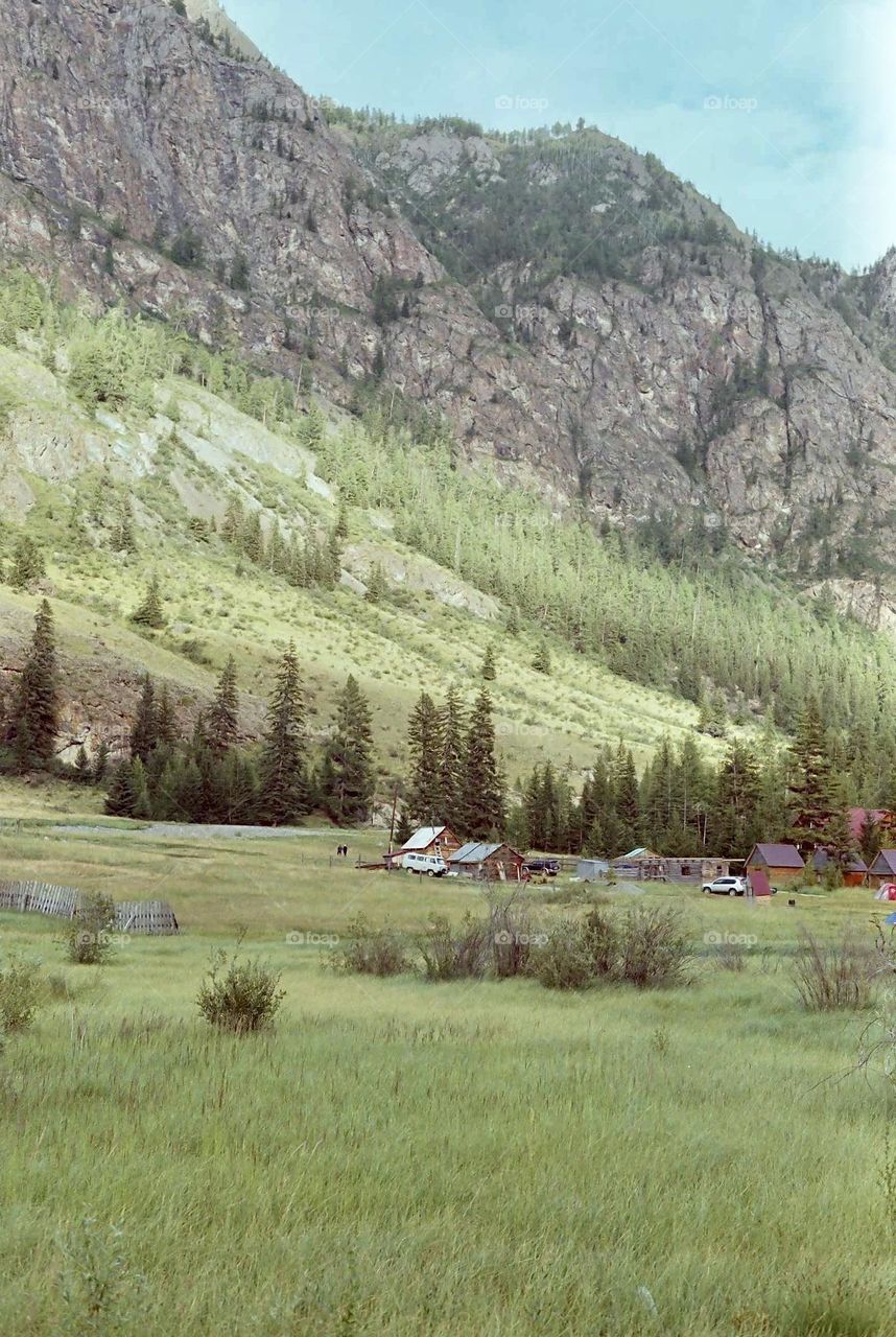 Green mountain with houses, shot on film 