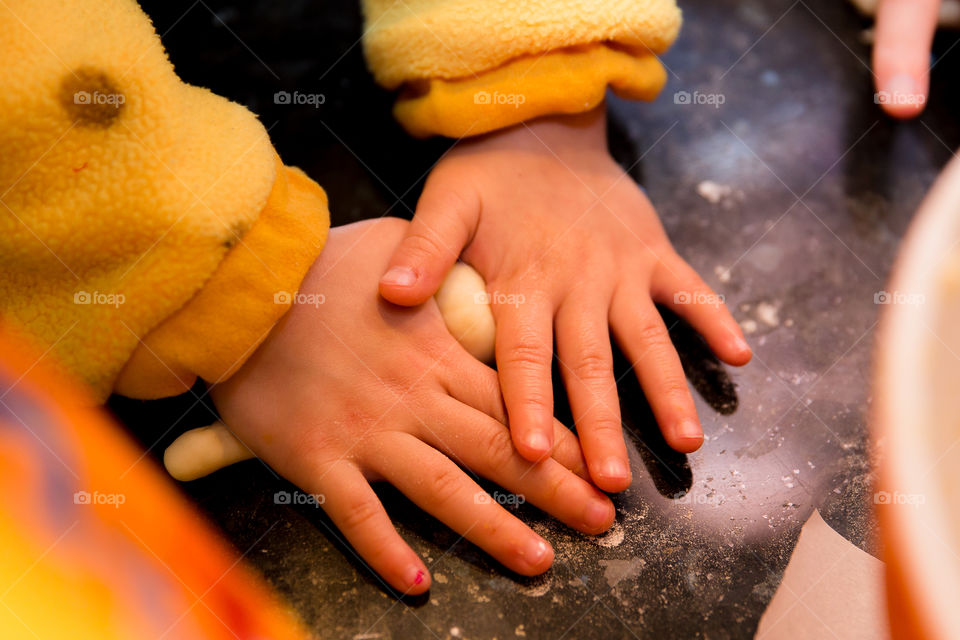 Close-up of a child's hand kneading dough