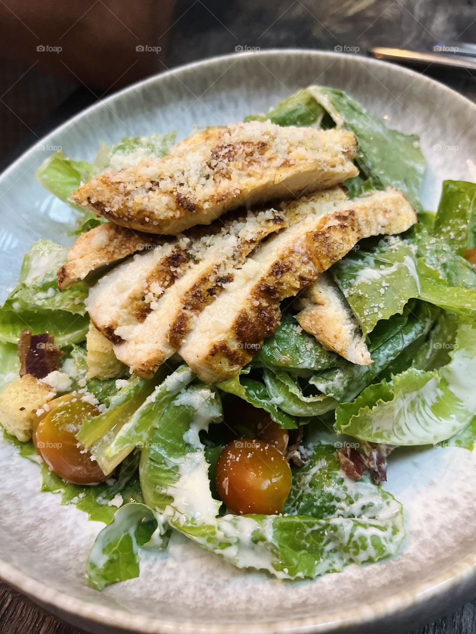 A plate of Caesar salad with chicken