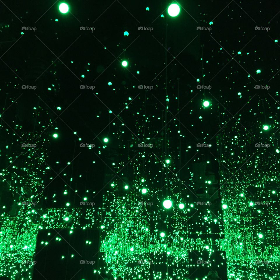 Light art exhibition. Green lights flickering in a dark room