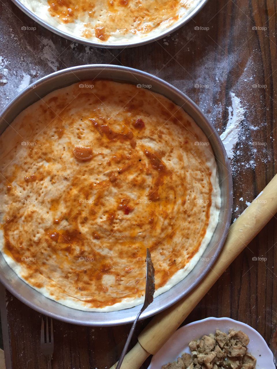 Adding tomato sauce to make pizza