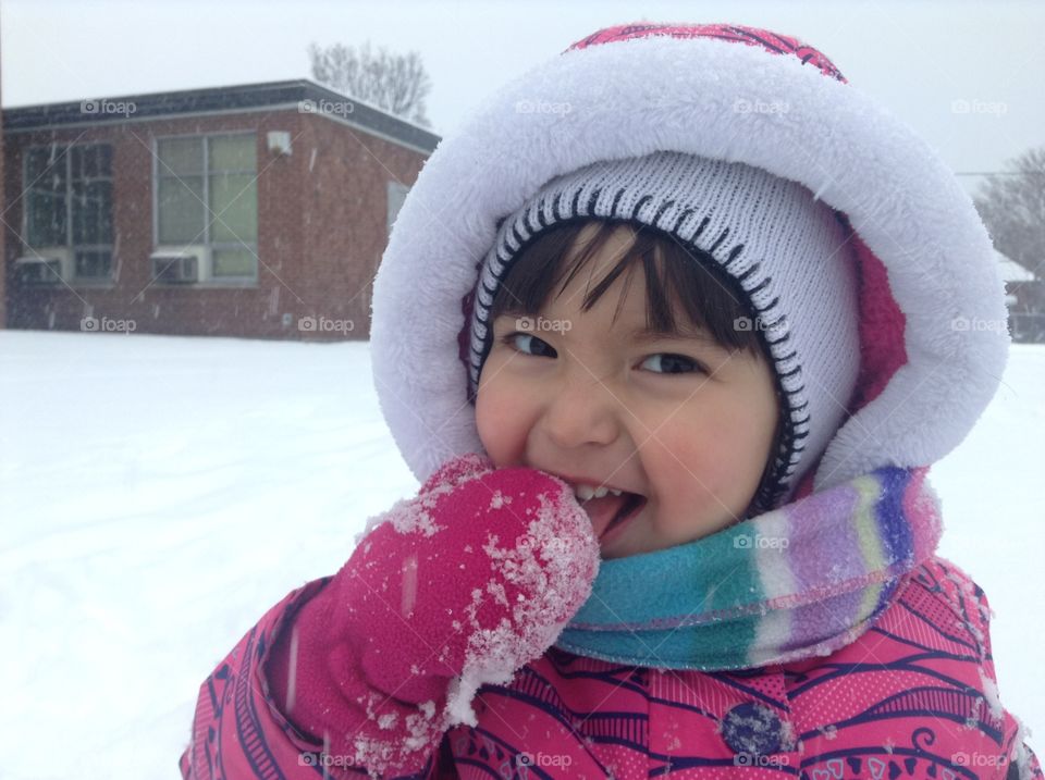 Cute little girl is enjoying snow outdoors