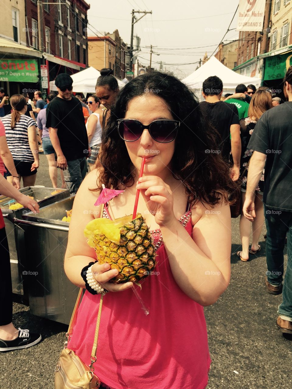 Woman drink cocktail pineapple with straw at market