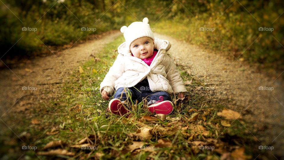 Cute baby girl sitting in grass