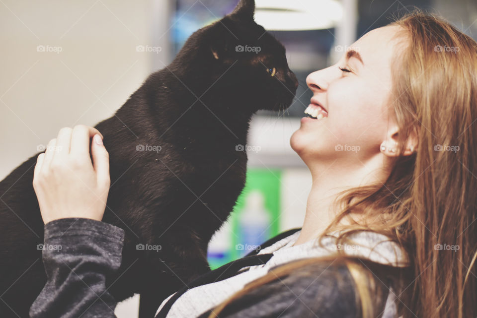 Girl hugging black cat