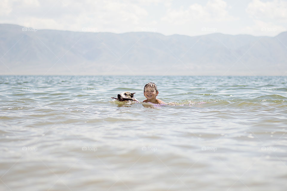 boy with dog in a water