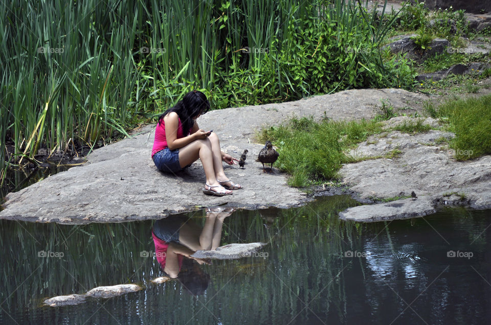 Girl by the lake with ducks