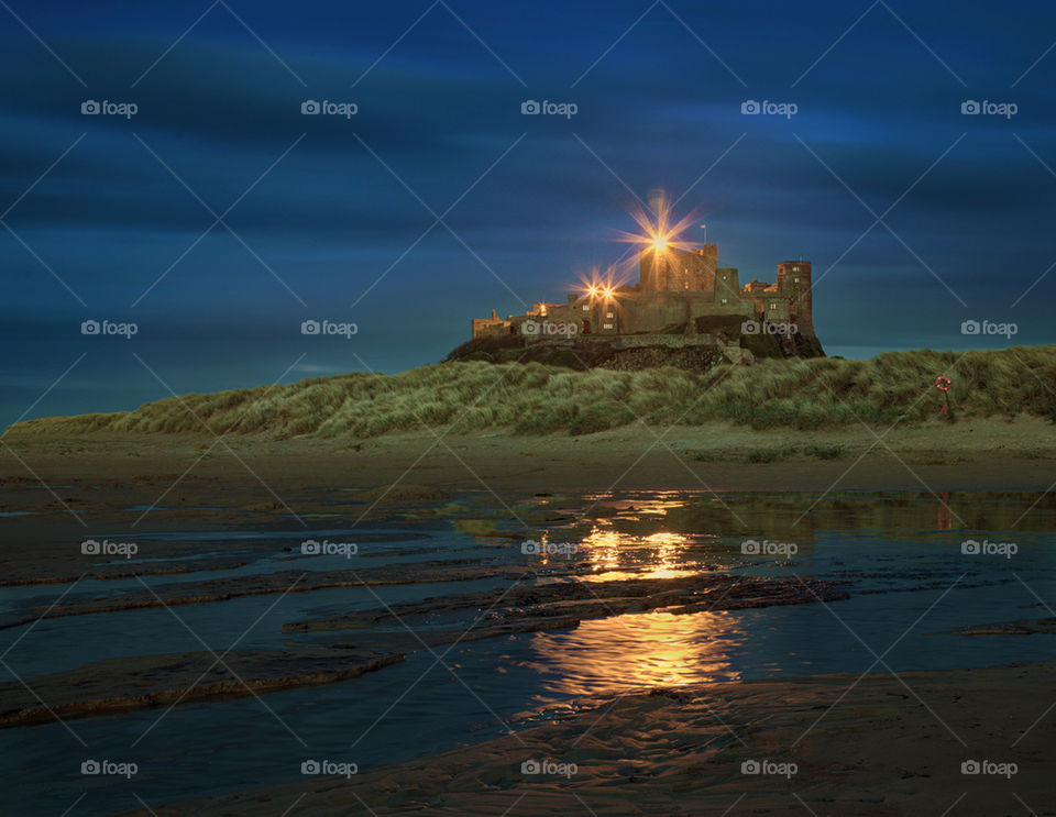 Bamburgh castle sunset. The sun sets on Northumberland's Bamburgh Castle