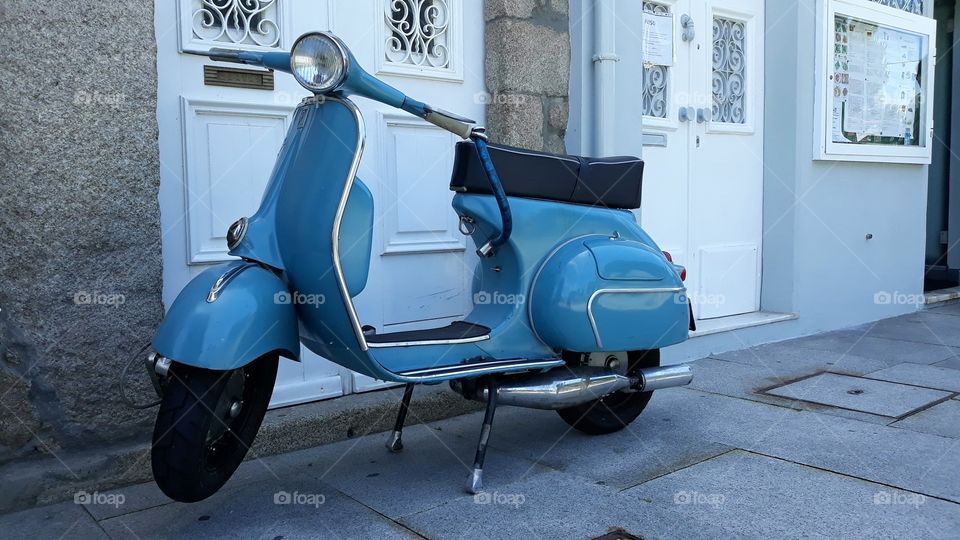 Scooter parked on sidewalk in the city of Porto, Portugal.