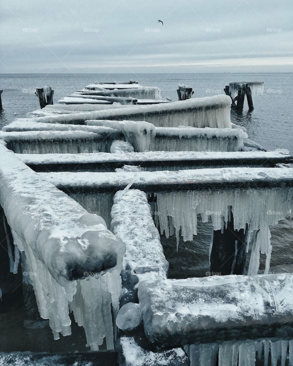 Frozen broken pier at sea