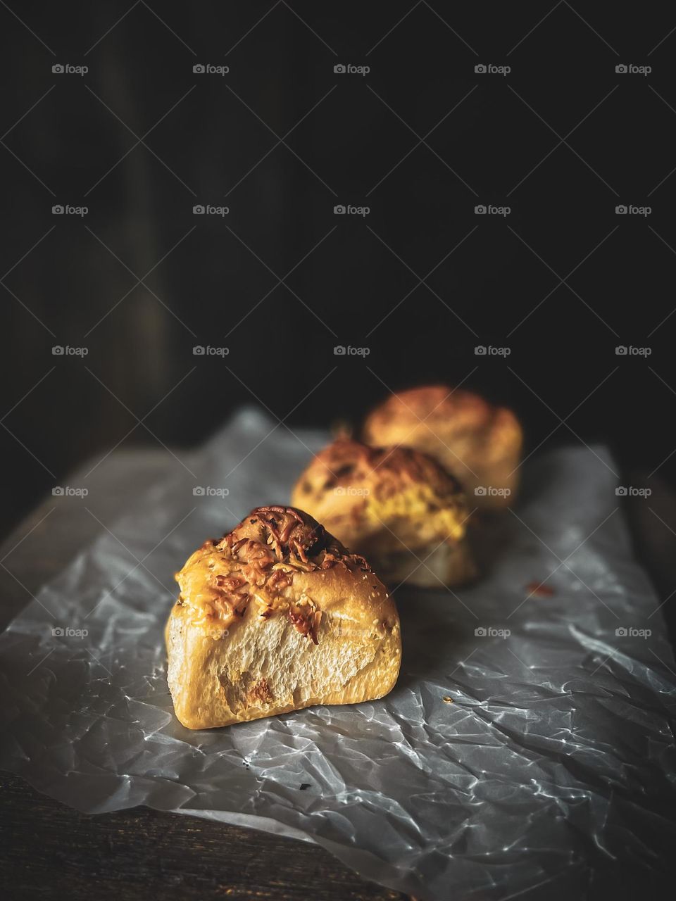 Cheese and bread with dark background on a baking sheet