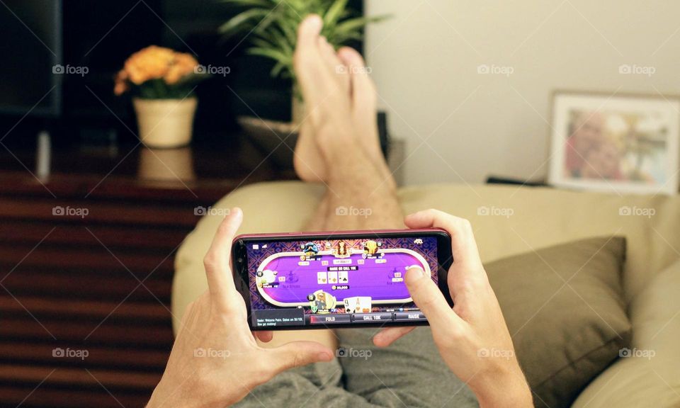 Boy playing on cellphone lying on couch