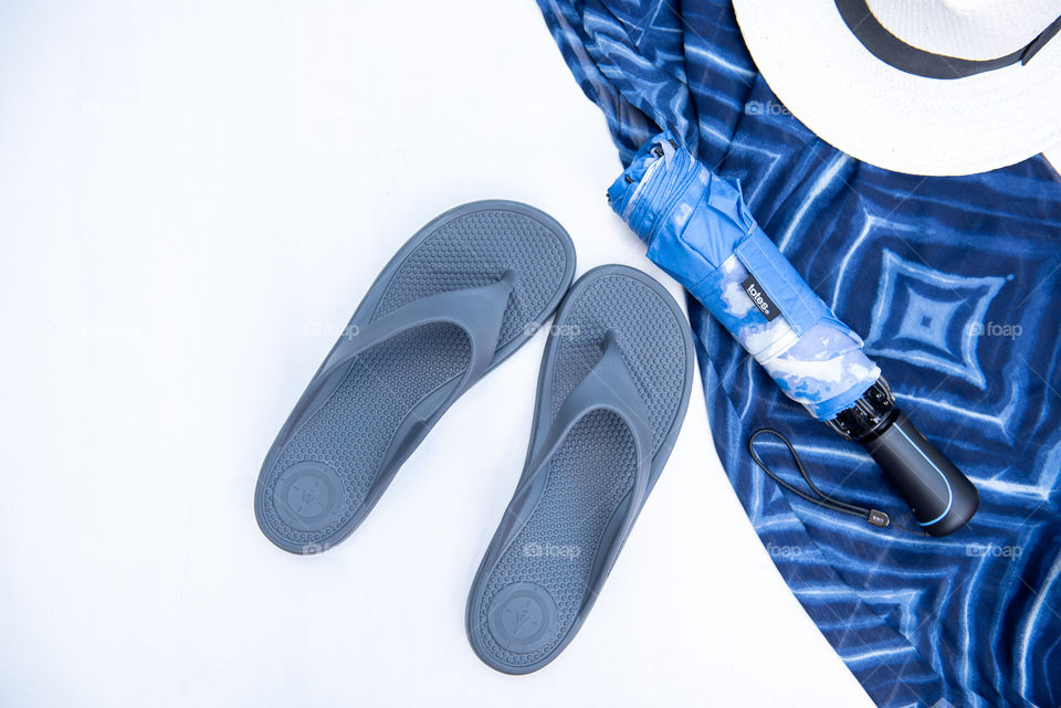 Flat lay of a pair of women's sandals and an umbrella