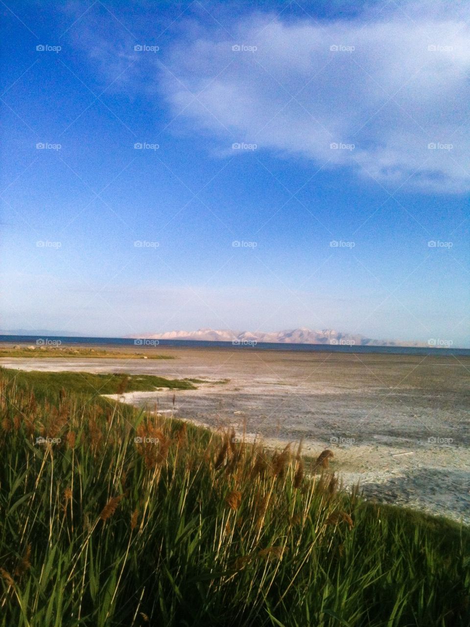 Salt Lake in Utah, dry, but with blue mostly clear skies, and mountains off in the distance