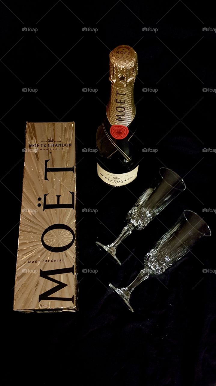 Bottle of Champagne with gift box and two glasses on dark background - en flaska champagne och två glas 