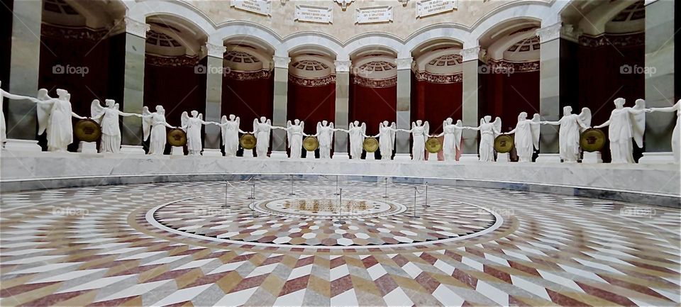 This is “Liberation Hall” in “Kelheim”, Bavaria. Built in the Greco-Roman classical style this colossal circular hall is lavishly decorated with a multifaceted checked mosaic floor and large angels on pedestals all around. 2024. Hypnotic Productions