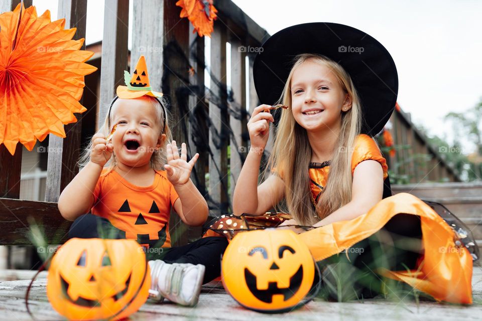 Happy kids in witch costume celebrating Halloween 