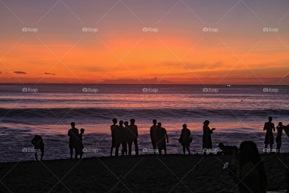 Surfer's Sunset. Local surfers at Dreamland Beach, Indonesia