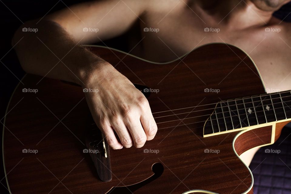 Man playing guitar in his bedroom