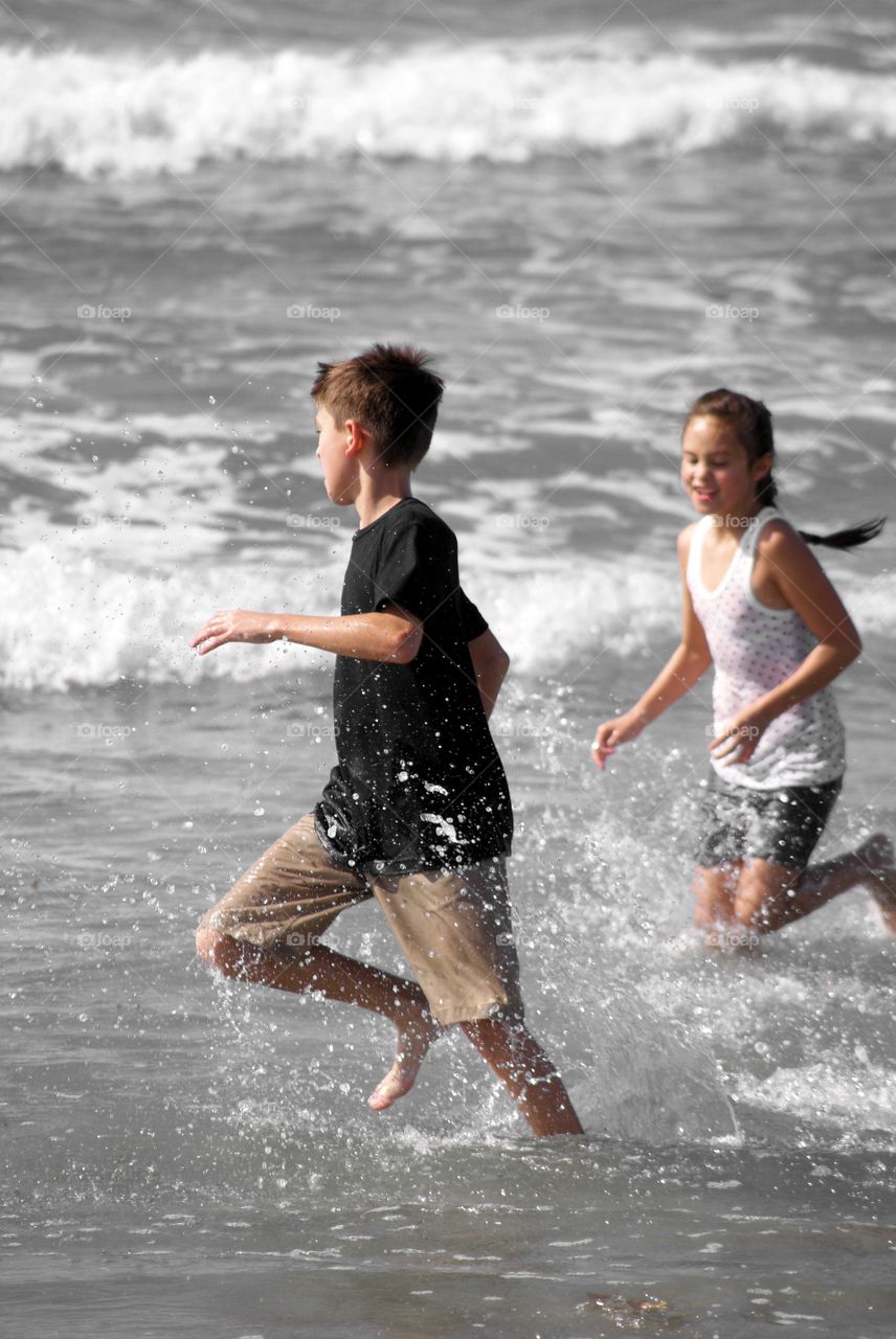 Young brother and sister playing beach