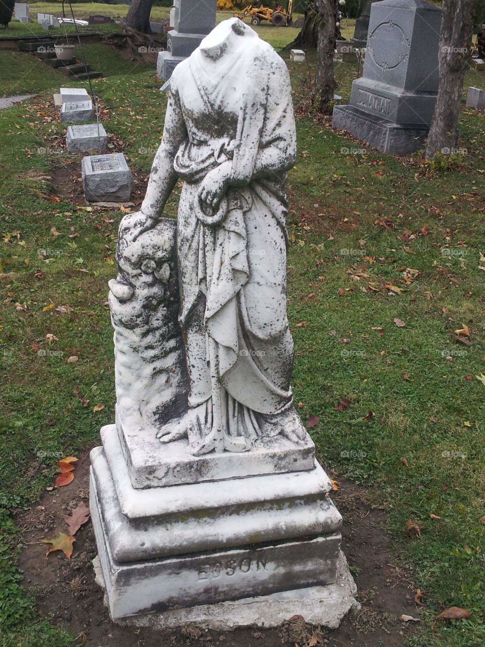 Headless statue in cemetery