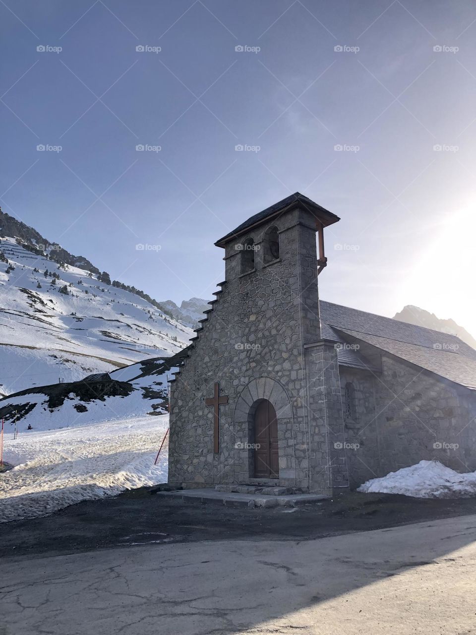 Church at the mountain surrounded by snow during sunset in a blue sky 