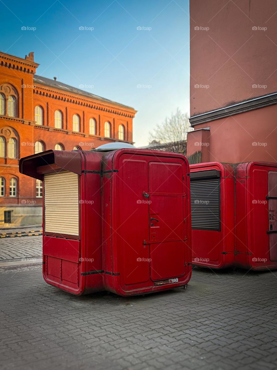 Old red selling counters on the street market in Poland, old building in the background 
