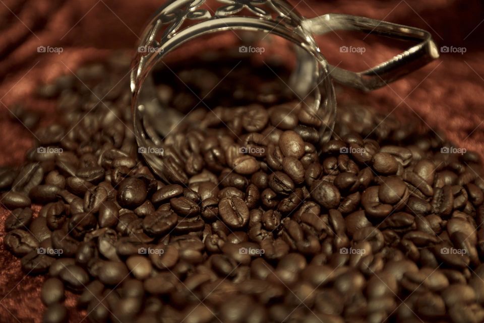 Fragrant coffee beans are scattered on a red background. Roasted coffee beans close up.