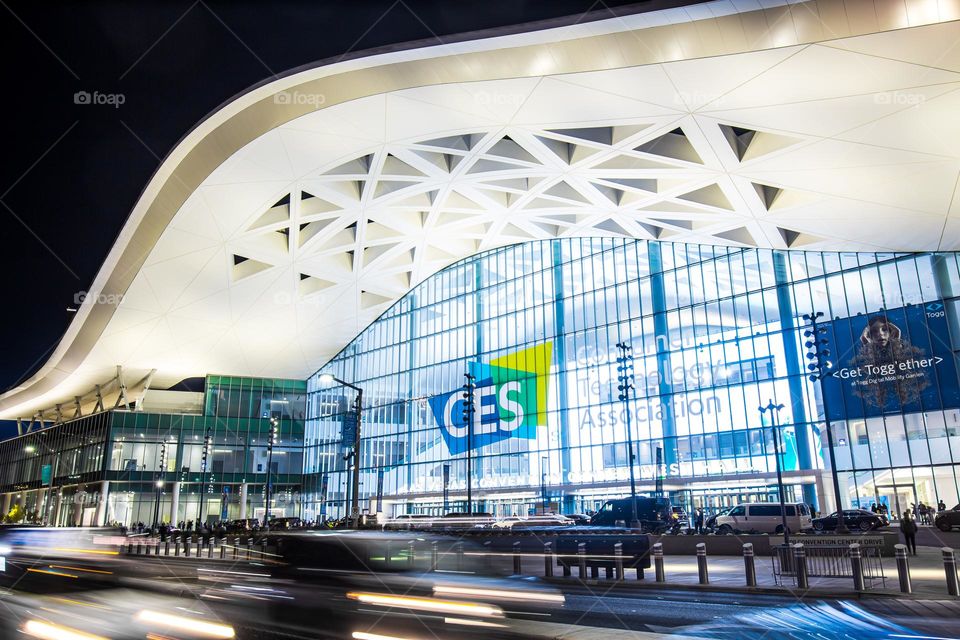 Las Vegas, NV, USA 1-6-2023: Exterior of Convention Center West Hall during CES2023. Logo of CES on glass wall. Light trails from car headlights of traffic passing by. Captured in long exposure.