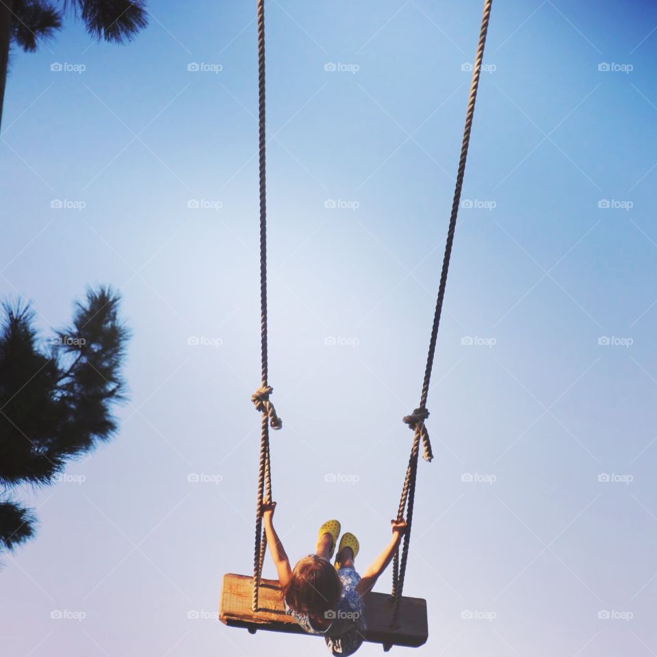 Girl on swing. little girl swinging on a long rope swing