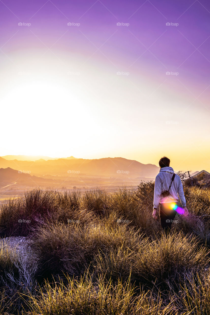 Young explorer at the top of a mountain on a foggy morning