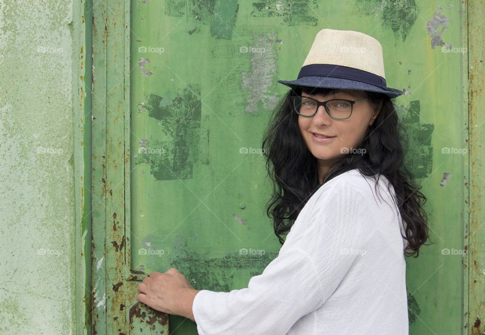 Portrait of beautiful woman on green door background