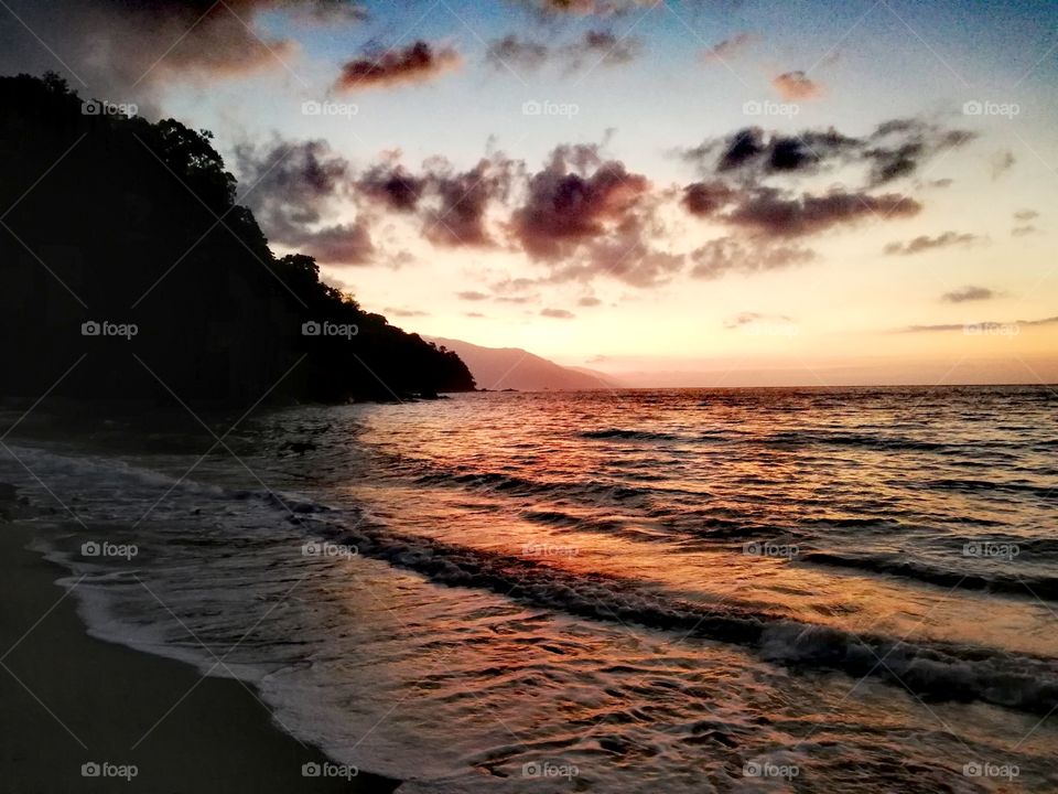 Beautiful orange red sunset over tropical sea on exotic tropical beach in Mindoro, Island of Philippines