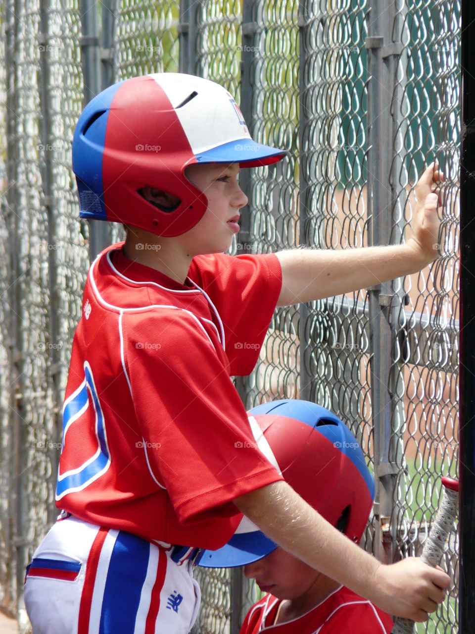 Youth baseball player in the dugout. 
