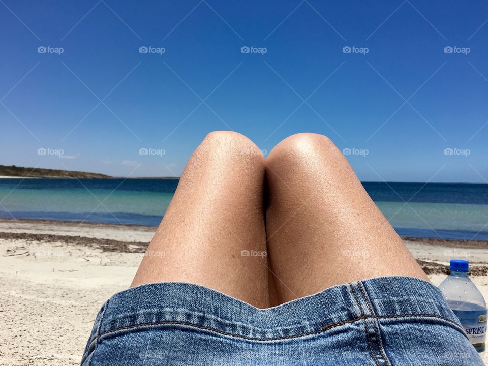 Remote white sand beach, woman's legs showing perspective 