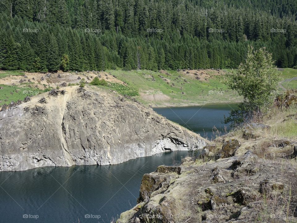Cougar Reservoir in Oregon sits among rocky banks and the stumps of long gone trees. 