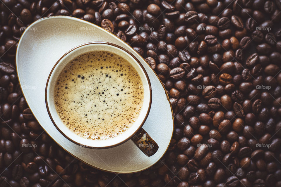 Espresso cup on coffee beans