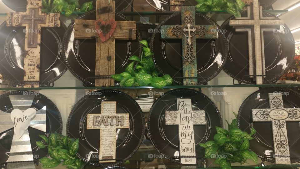 art display of rustic cross on plates stand.