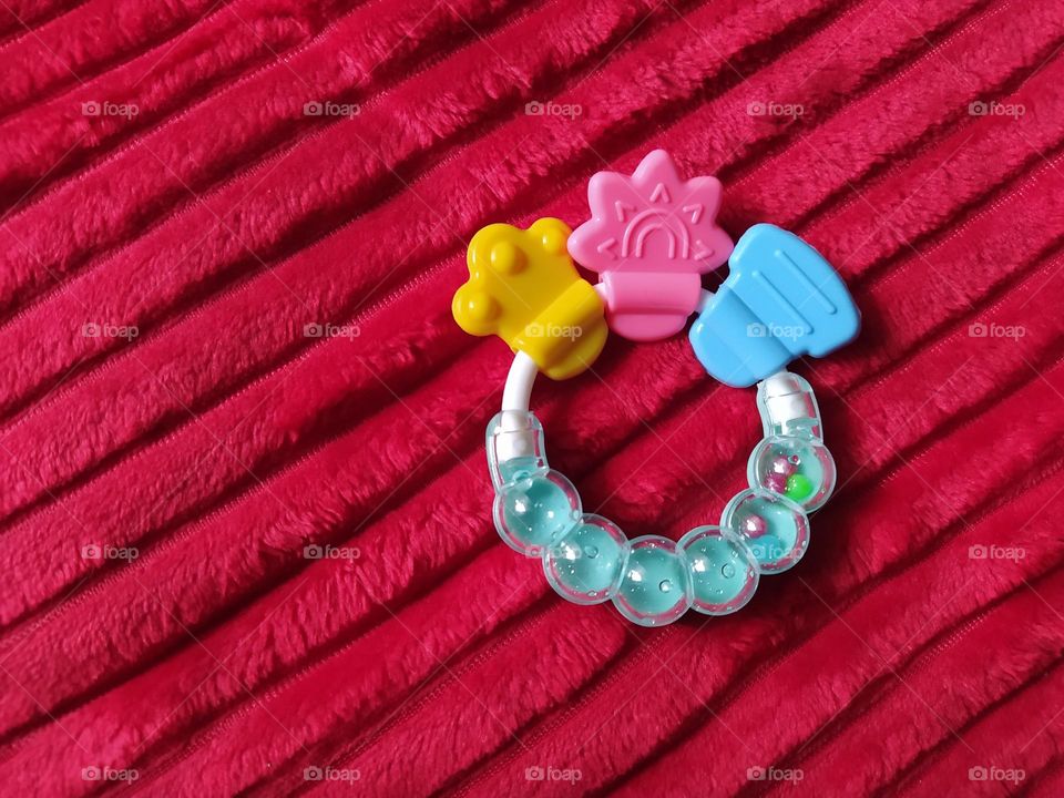 Baby teether on a red blanket